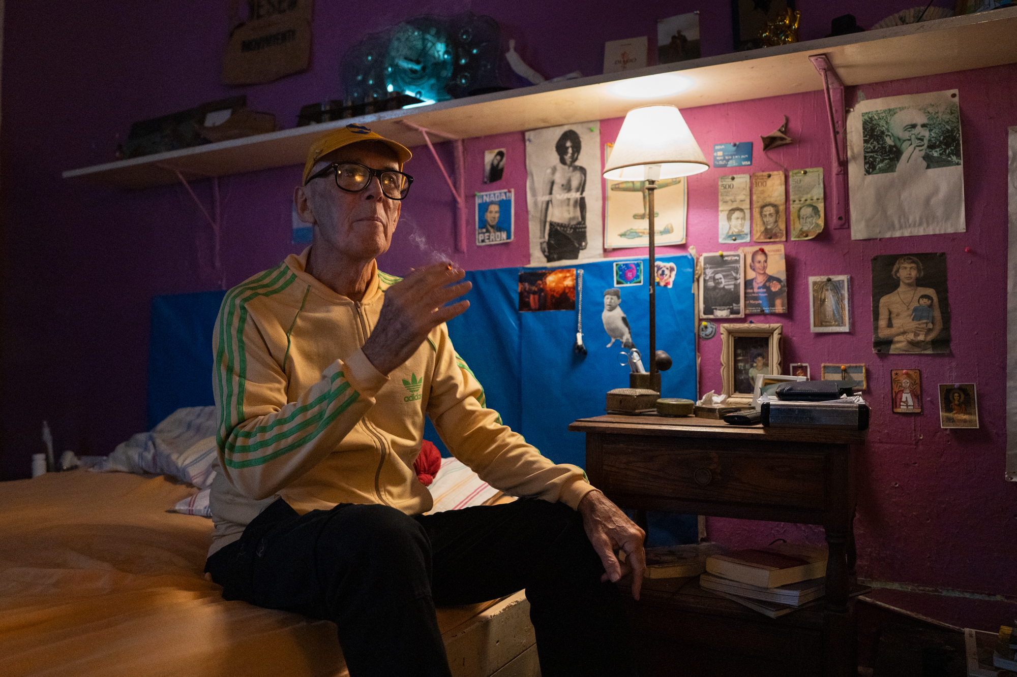 Un hombre fuma en su cama.
