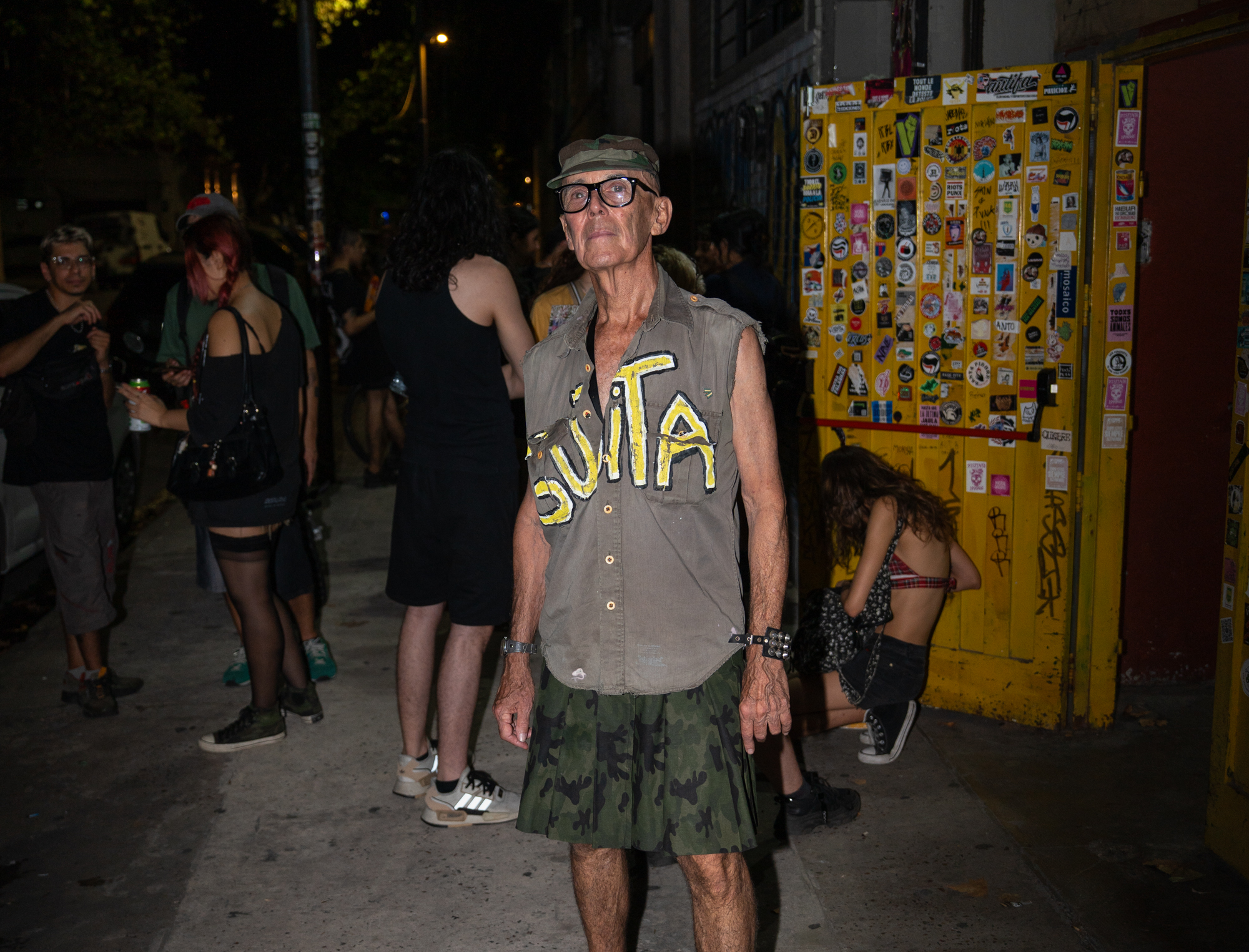 Un hombre está afuera de una puerta amarilla.