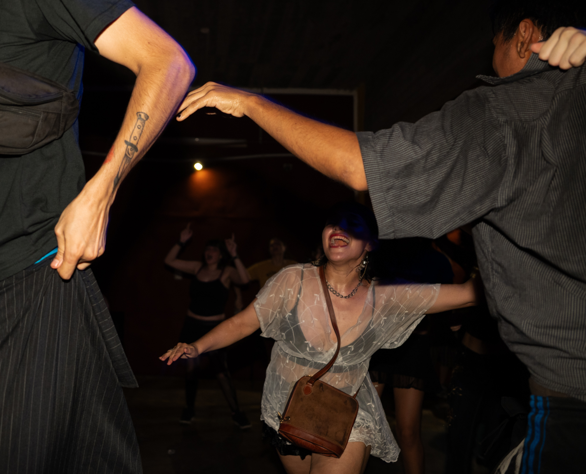 Personas jóvenes se mueven en la oscuridad de un show.